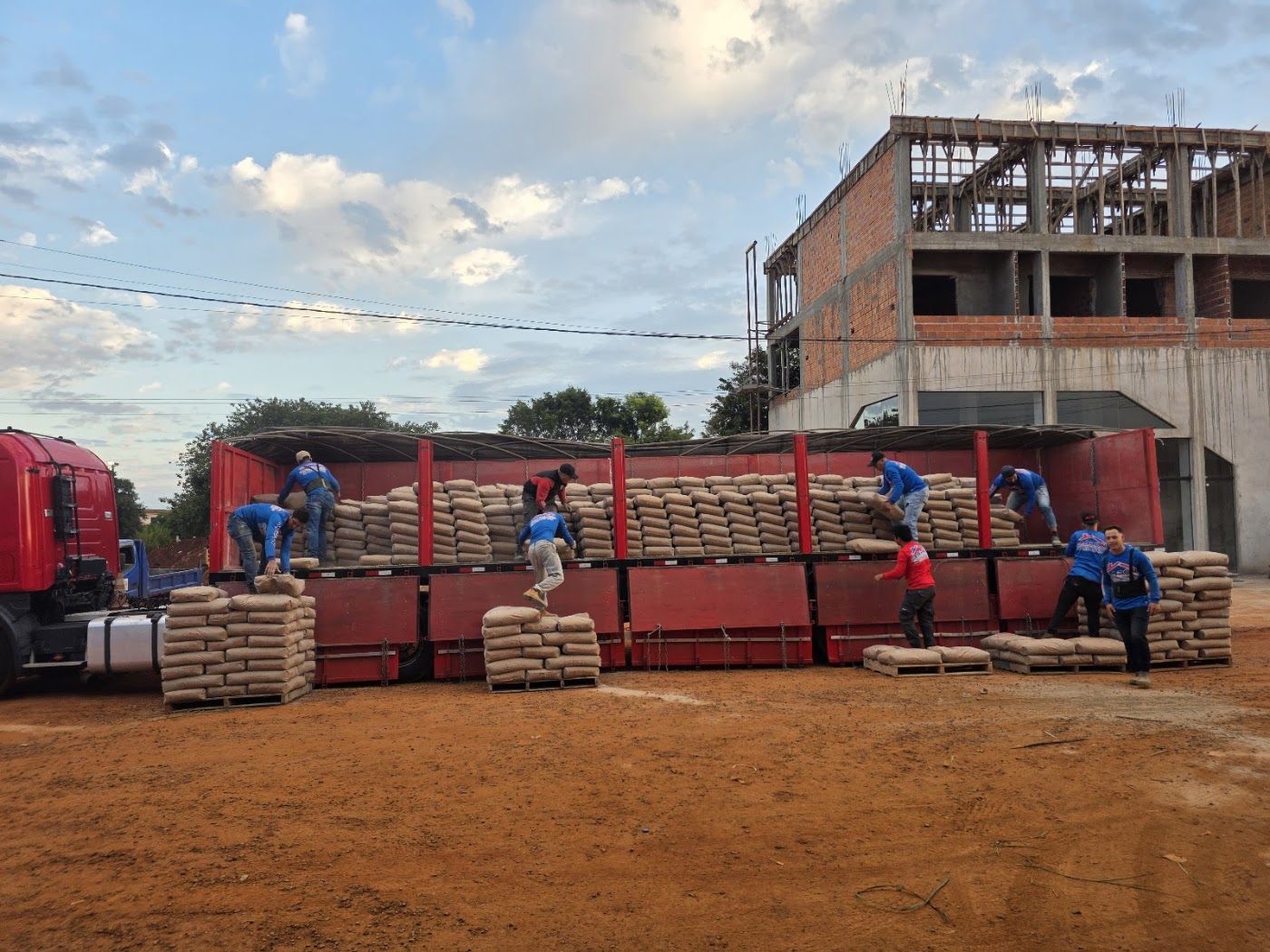 Equipo de Aarón cargando ladrillos y cemento en el camión